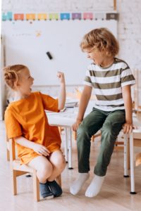 Two children enjoying playful moments indoors, showcasing joy and friendship.